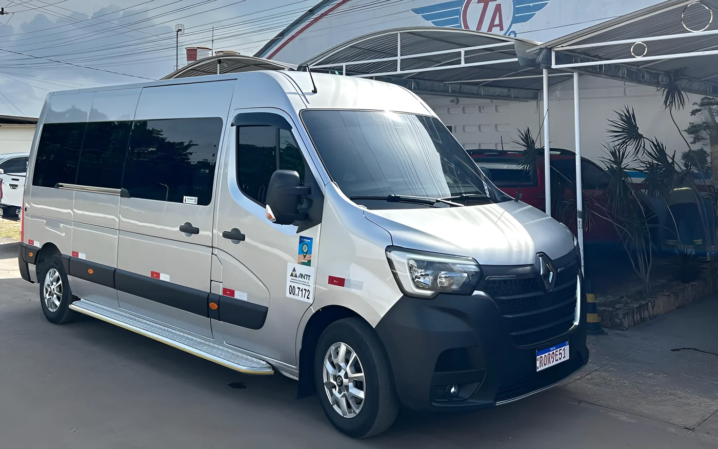 Van Renault Master prata da WM, com selo ANTT, estacionada em frente a um galpão